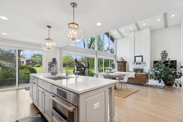 3118 River Falls Dr, Northbrook, IL 60062 - kitchen featuring a chandelier, light wood-style floors, recessed lighting, a fireplace, and an island with sink