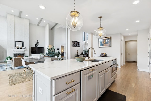 3118 River Falls Dr, Northbrook, IL 60062 - kitchen with stainless steel oven, gray cabinets, a center island with sink, light wood-type flooring, and recessed lighting