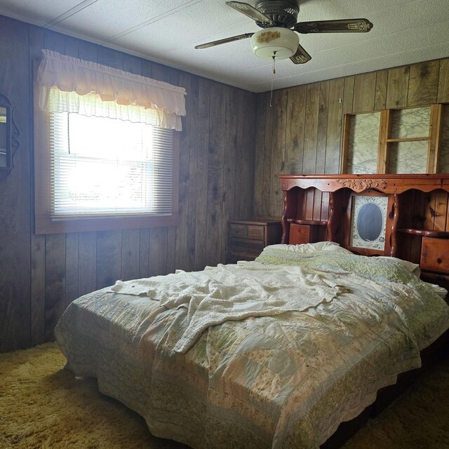 16306 W Canada Rd, Polo, IL 61064 - carpeted bedroom featuring wood walls and ceiling fan