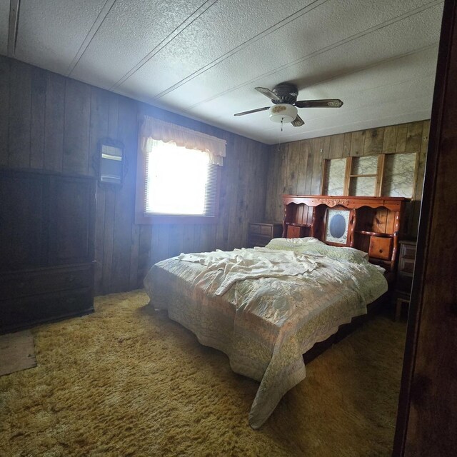 16306 W Canada Rd, Polo, IL 61064 - carpeted bedroom with wood walls, a ceiling fan, and a textured ceiling