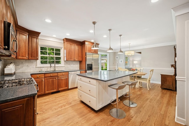 200 W Center Ave, Lake Bluff, IL 60044 - kitchen featuring stainless steel appliances, tasteful backsplash, a kitchen breakfast bar, light wood finished floors, and ornamental molding