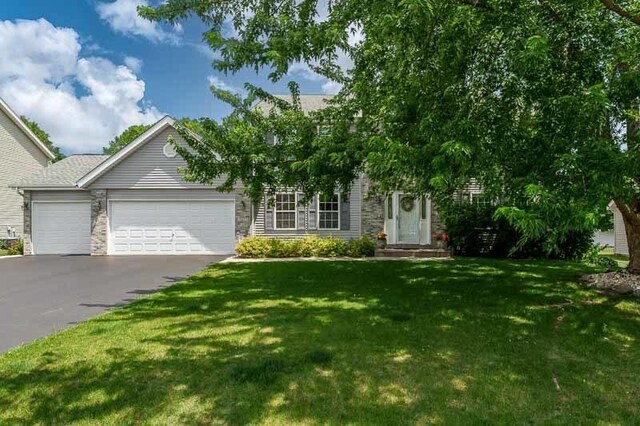 10873 Meadowsweet Ln, Roscoe, IL 61073 - obstructed view of property with a garage, a front lawn, and asphalt driveway