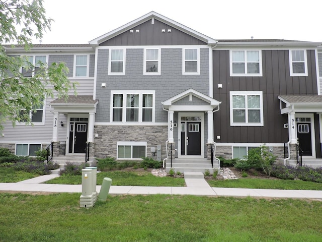 516 Wolverine Dr, Aurora, IL 60502 - view of front of house with stone siding, board and batten siding, and a front yard