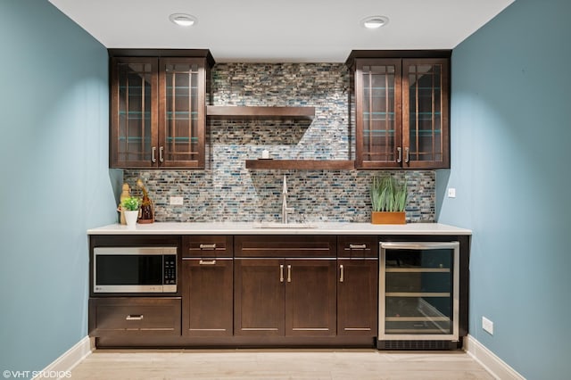 2865 Trail Crest Ln, Lindenhurst, IL 60046 - indoor wet bar featuring stainless steel microwave, beverage cooler, tasteful backsplash, light wood-style flooring, and recessed lighting
