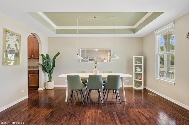 2865 Trail Crest Ln, Lindenhurst, IL 60046 - dining space featuring a raised ceiling, dark wood-style floors, ornamental molding, and arched walkways