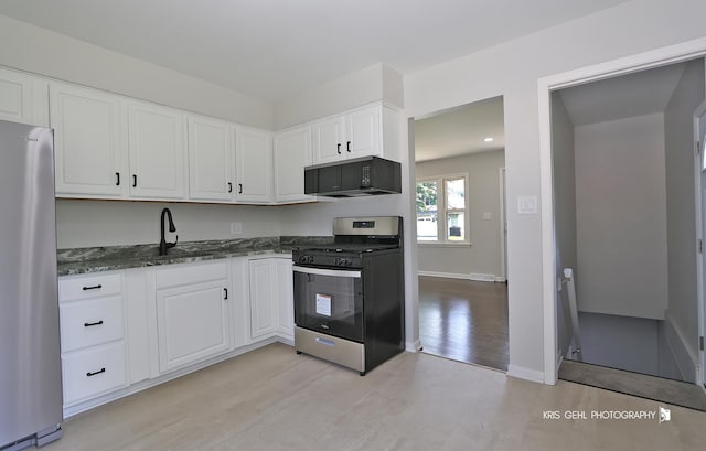 5505 Oak Park Rd, Cary, IL 60013 - kitchen featuring stainless steel appliances, white cabinets, dark stone counters, and light wood-style flooring