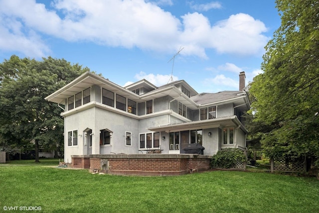 710 W Downer Pl, Aurora, IL 60506 - view of front facade featuring stucco siding, a front lawn, and a chimney
