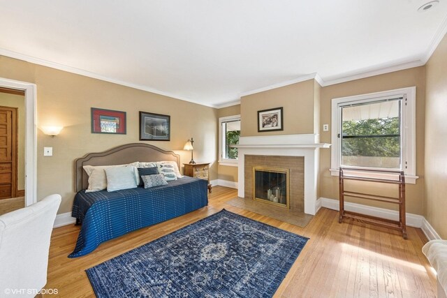 710 W Downer Pl, Aurora, IL 60506 - bedroom with wood finished floors, a brick fireplace, and ornamental molding