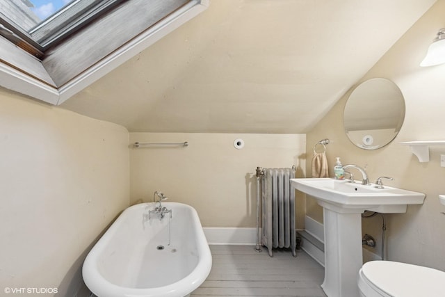 710 W Downer Pl, Aurora, IL 60506 - full bathroom with radiator heating unit, a freestanding tub, hardwood / wood-style flooring, vaulted ceiling, and a skylight