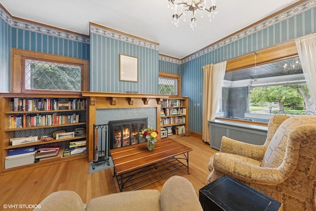 710 W Downer Pl, Aurora, IL 60506 - living area featuring wallpapered walls, a glass covered fireplace, wood finished floors, a chandelier, and radiator