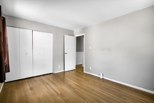 22255 Merrill Ave, Sauk Village, IL 60411 - unfurnished bedroom with wood finished floors and a closet