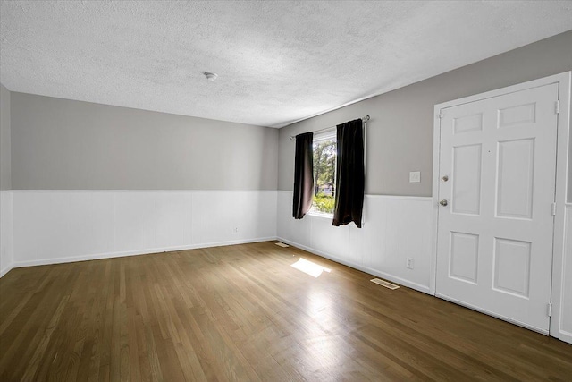 22255 Merrill Ave, Sauk Village, IL 60411 - spare room with wood finished floors, wainscoting, and a textured ceiling