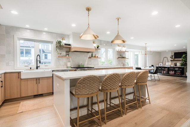 438 Hill Ave, Glen Ellyn, IL 60137 - kitchen with open shelves, light wood finished floors, backsplash, a center island, and light brown cabinetry