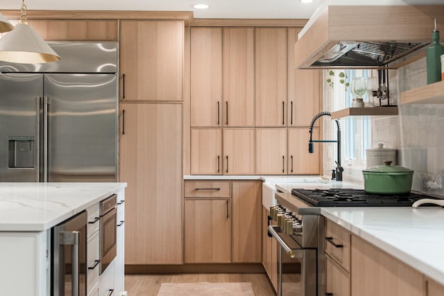 438 Hill Ave, Glen Ellyn, IL 60137 - kitchen with wall chimney exhaust hood, high end appliances, beverage cooler, light brown cabinetry, and light stone counters