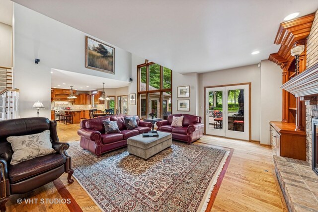 3104 Royal Fox Dr, Saint Charles, IL 60174 - living room with light wood-type flooring, a brick fireplace, recessed lighting, and a towering ceiling