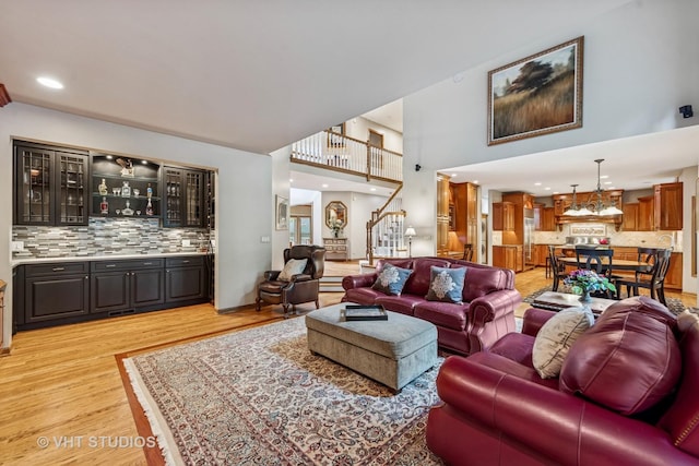 3104 Royal Fox Dr, Saint Charles, IL 60174 - living area with light wood-style flooring, wet bar, stairs, and a high ceiling