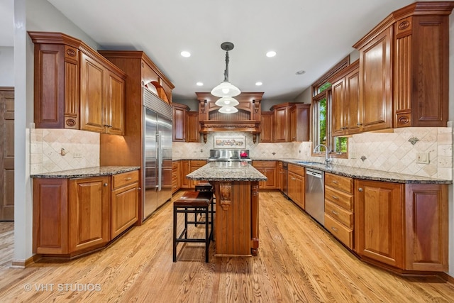 3104 Royal Fox Dr, Saint Charles, IL 60174 - kitchen with appliances with stainless steel finishes, light wood finished floors, brown cabinets, recessed lighting, and light stone counters