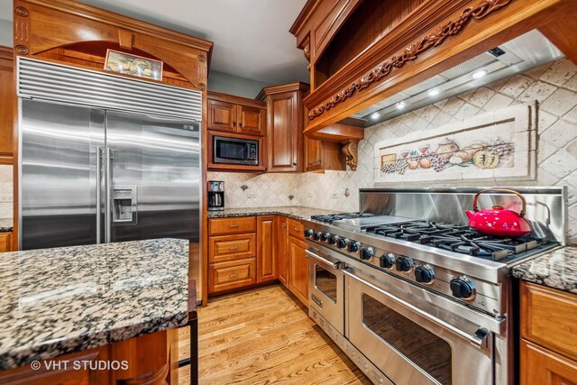3104 Royal Fox Dr, Saint Charles, IL 60174 - kitchen featuring built in appliances, premium range hood, light wood-type flooring, decorative backsplash, and light stone countertops