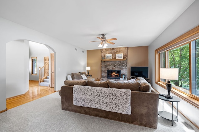 2717 Meadow Path, New Lenox, IL 60451 - carpeted living room with ceiling fan, a brick fireplace, arched walkways, stairway, and wood finished floors