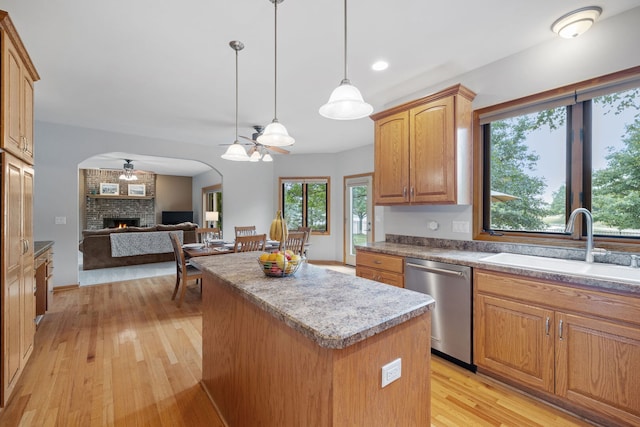 2717 Meadow Path, New Lenox, IL 60451 - kitchen with stainless steel dishwasher, a ceiling fan, a kitchen island, light wood-style floors, and a fireplace