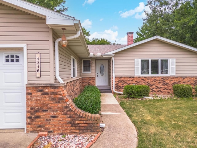 1316 Kirkwood Dr, Pontiac, IL 61764 - doorway to property featuring brick siding, a chimney, a yard, and a garage