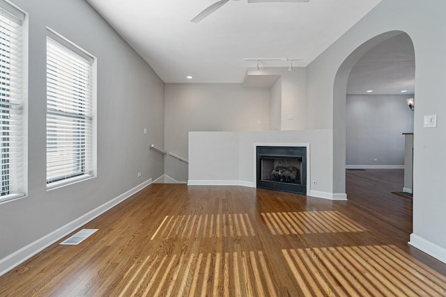 7438 N Hermitage Ave Unit 1E, Chicago, IL 60626 - unfurnished living room with wood finished floors, track lighting, a ceiling fan, arched walkways, and a fireplace