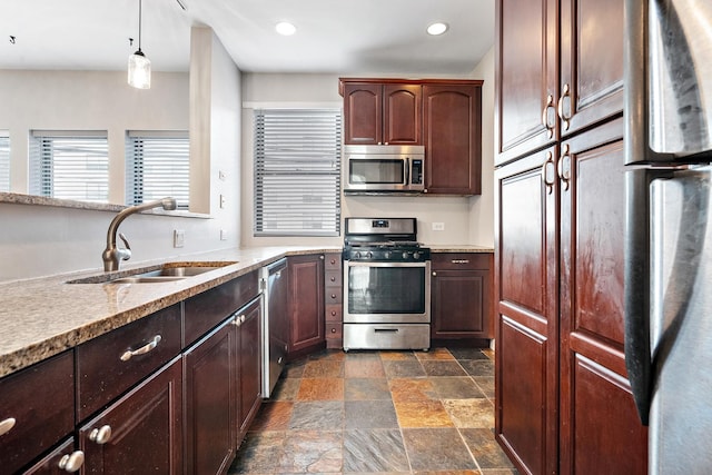 7438 N Hermitage Ave Unit 1E, Chicago, IL 60626 - kitchen with appliances with stainless steel finishes, stone tile flooring, recessed lighting, hanging light fixtures, and dark brown cabinetry