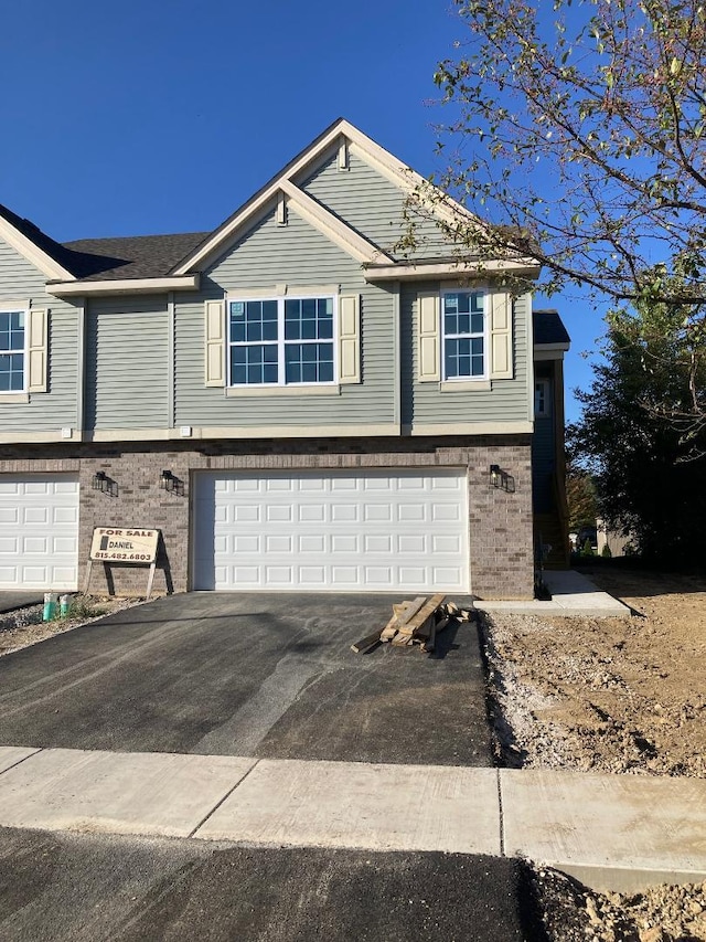 939 Saddle Ridge Dr, Joliet, IL 60432 - view of property exterior with an attached garage, brick siding, and driveway
