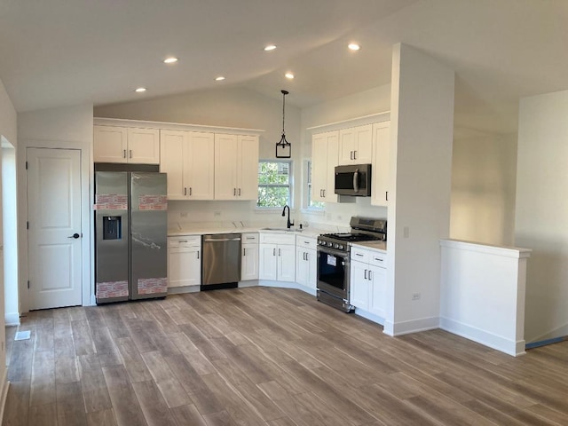 939 Saddle Ridge Dr, Joliet, IL 60432 - kitchen featuring stainless steel appliances, wood finished floors, light countertops, white cabinets, and lofted ceiling