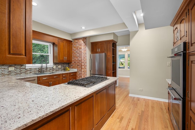 4416 Seeley Ave, Downers Grove, IL 60515 - kitchen featuring appliances with stainless steel finishes, decorative backsplash, light stone countertops, light wood-type flooring, and brown cabinets