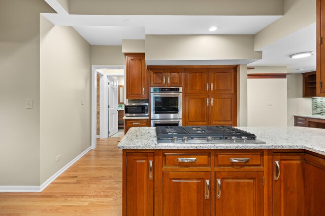 4416 Seeley Ave, Downers Grove, IL 60515 - kitchen featuring stainless steel appliances, light stone countertops, light wood-type flooring, and brown cabinetry