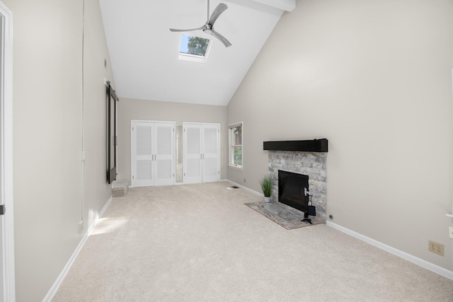 4416 Seeley Ave, Downers Grove, IL 60515 - unfurnished living room with ceiling fan, high vaulted ceiling, carpet flooring, a stone fireplace, and a skylight