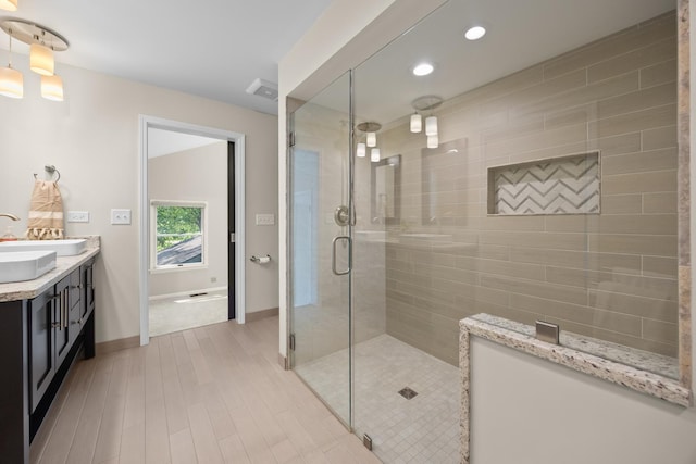 4416 Seeley Ave, Downers Grove, IL 60515 - bathroom with double vanity, a stall shower, wood finished floors, and recessed lighting