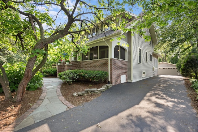 4416 Seeley Ave, Downers Grove, IL 60515 - view of side of home featuring brick siding, an outdoor structure, a garage, and a sunroom