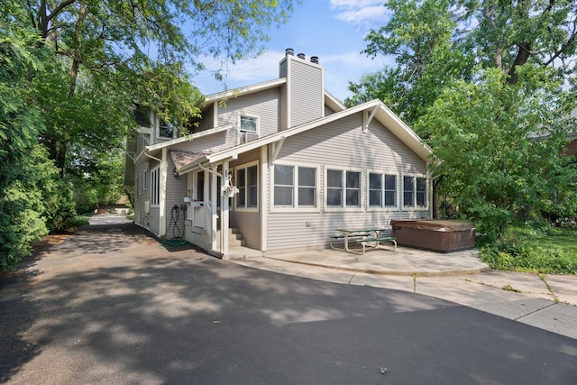4416 Seeley Ave, Downers Grove, IL 60515 - back of property with a hot tub, a patio area, and a chimney