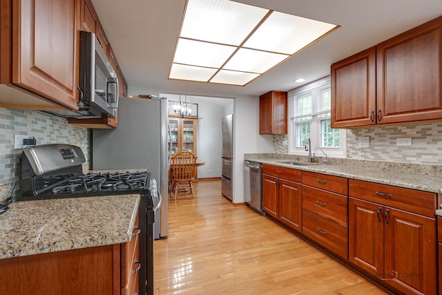 4900 Dukesberry Ln, Hoffman Estates, IL 60010 - kitchen with stainless steel appliances, a chandelier, light wood-style floors, and tasteful backsplash