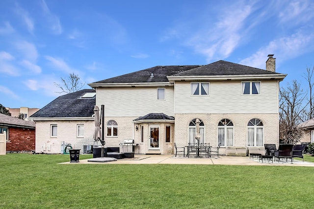 7830 W 157th St, Orland Park, IL 60462 - rear view of house featuring a chimney, a patio area, a lawn, and brick siding