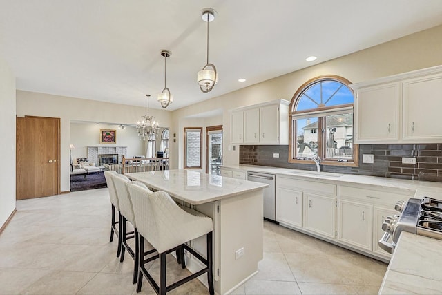 7830 W 157th St, Orland Park, IL 60462 - kitchen featuring appliances with stainless steel finishes, tasteful backsplash, a center island, light tile patterned floors, and white cabinets