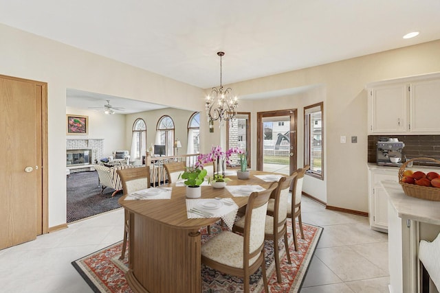 7830 W 157th St, Orland Park, IL 60462 - dining area featuring a glass covered fireplace, light tile patterned floors, a chandelier, and ceiling fan