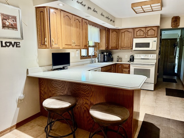 241 E Porter St, Oglesby, IL 61348 - kitchen featuring white appliances, a peninsula, light countertops, and light tile patterned floors