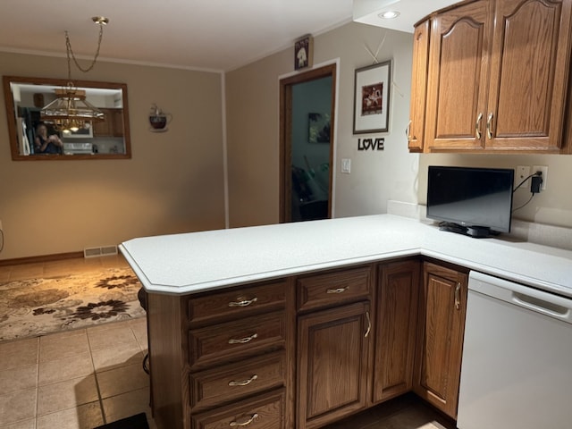 241 E Porter St, Oglesby, IL 61348 - kitchen featuring white dishwasher, a peninsula, light countertops, hanging light fixtures, and tile patterned floors
