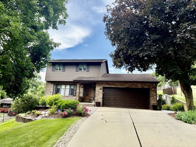 241 E Porter St, Oglesby, IL 61348 - view of front of house with a garage, concrete driveway, and brick siding
