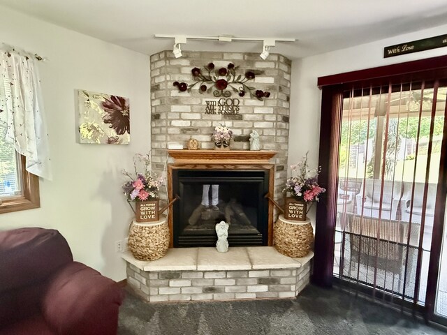 241 E Porter St, Oglesby, IL 61348 - carpeted living room featuring plenty of natural light, a brick fireplace, and rail lighting