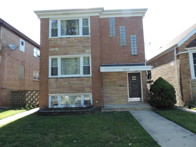 5063 N Menard Ave, Chicago, IL 60630 - view of front of house with stone siding, a front yard, and brick siding