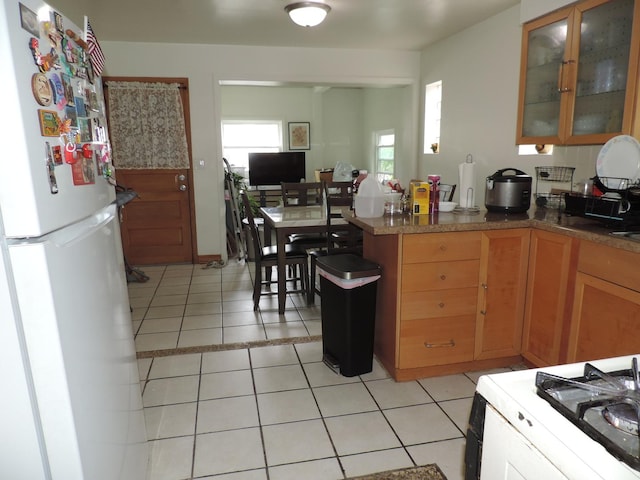 5063 N Menard Ave, Chicago, IL 60630 - kitchen with white appliances, light tile patterned flooring, glass insert cabinets, and a peninsula