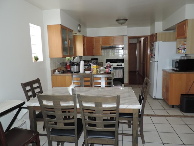 5063 N Menard Ave, Chicago, IL 60630 - kitchen featuring range, black microwave, decorative backsplash, under cabinet range hood, and freestanding refrigerator