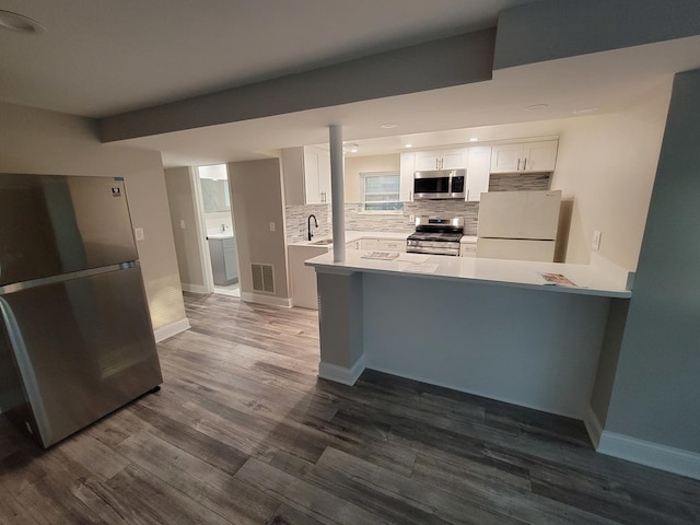 5063 N Menard Ave, Chicago, IL 60630 - kitchen with stainless steel appliances, white cabinets, decorative backsplash, and dark wood-type flooring
