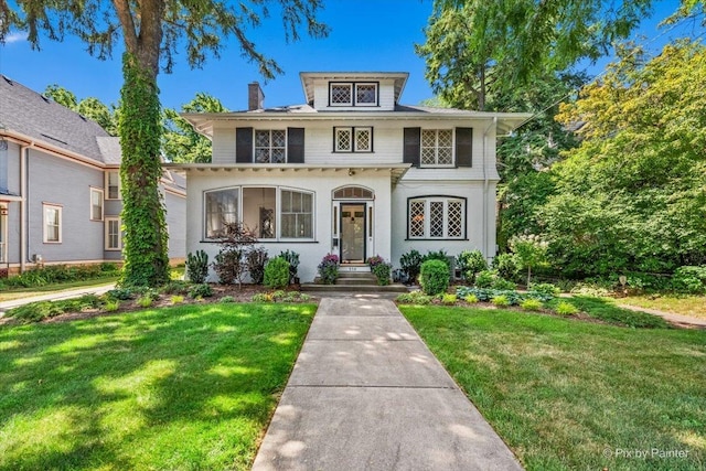 558 W Downer Pl, Aurora, IL 60506 - view of front facade featuring a chimney, a front lawn, and stucco siding