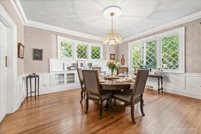 558 W Downer Pl, Aurora, IL 60506 - dining room featuring a decorative wall, a chandelier, crown molding, hardwood / wood-style flooring, and plenty of natural light