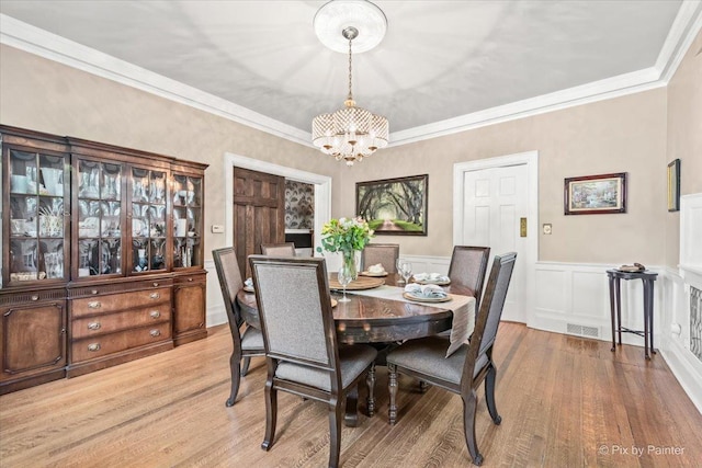 558 W Downer Pl, Aurora, IL 60506 - dining room featuring a chandelier, wood finished floors, wainscoting, and ornamental molding